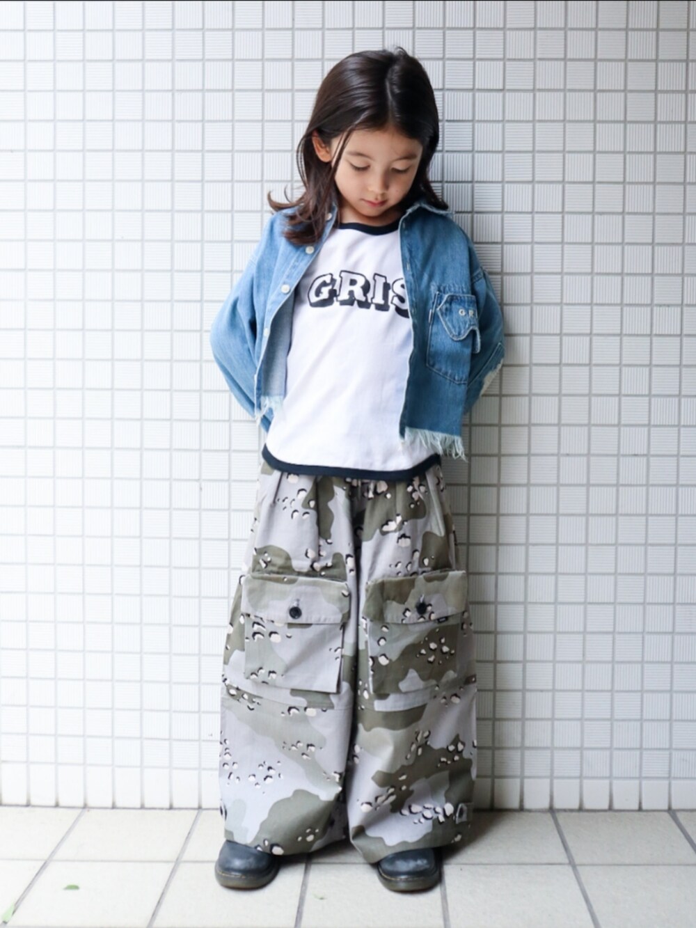 グレー系のパンツ、ホワイト系のタンクトップ、ブルー系のデニムジャケットを着用したキッズの秋コーディネートの2枚目の写真