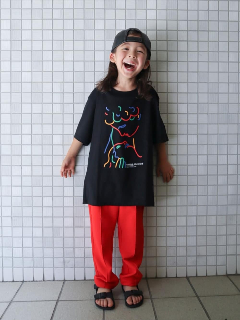 レッド系のその他パンツ、ブラック系のサンダル、ブラック系のTシャツ/カットソーを着用したキッズの夏コーディネートの2枚目の写真