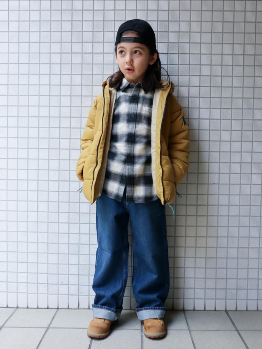 ベージュ系のブーツ、ベージュ系のダウンジャケット/コート、ブラック系のシャツ/ブラウスを着用したキッズの冬コーディネートの2枚目の写真