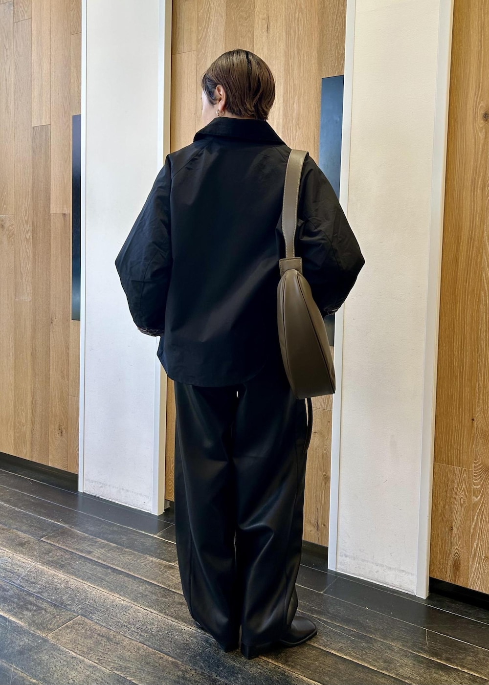 グリーン系のショルダーバッグ、ブラック系のブルゾン、ブラウン系のニット/セーターを着用したレディースの秋コーディネートの4枚目の写真