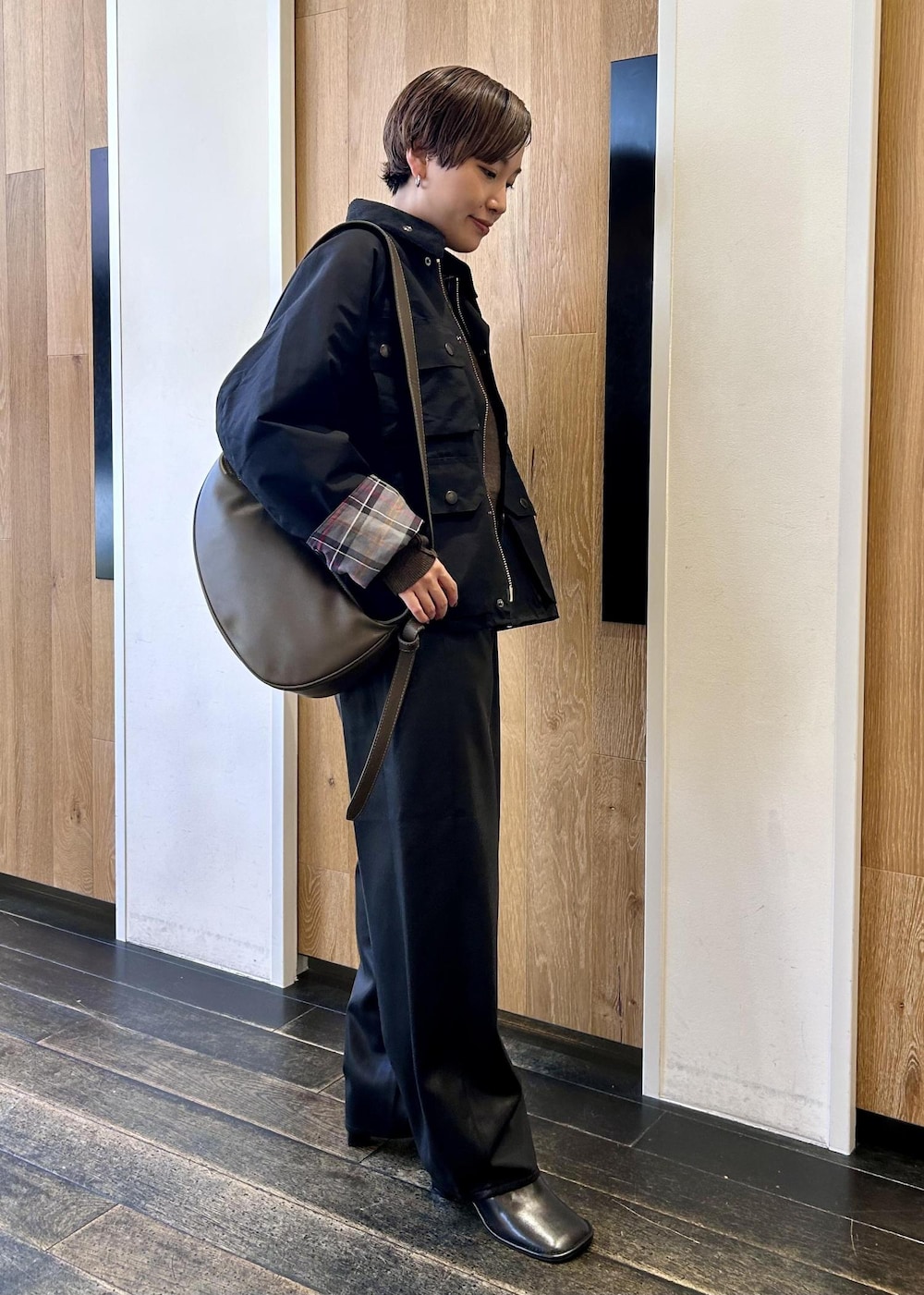 グリーン系のショルダーバッグ、ブラック系のブルゾン、ブラウン系のニット/セーターを着用したレディースの秋コーディネートの5枚目の写真