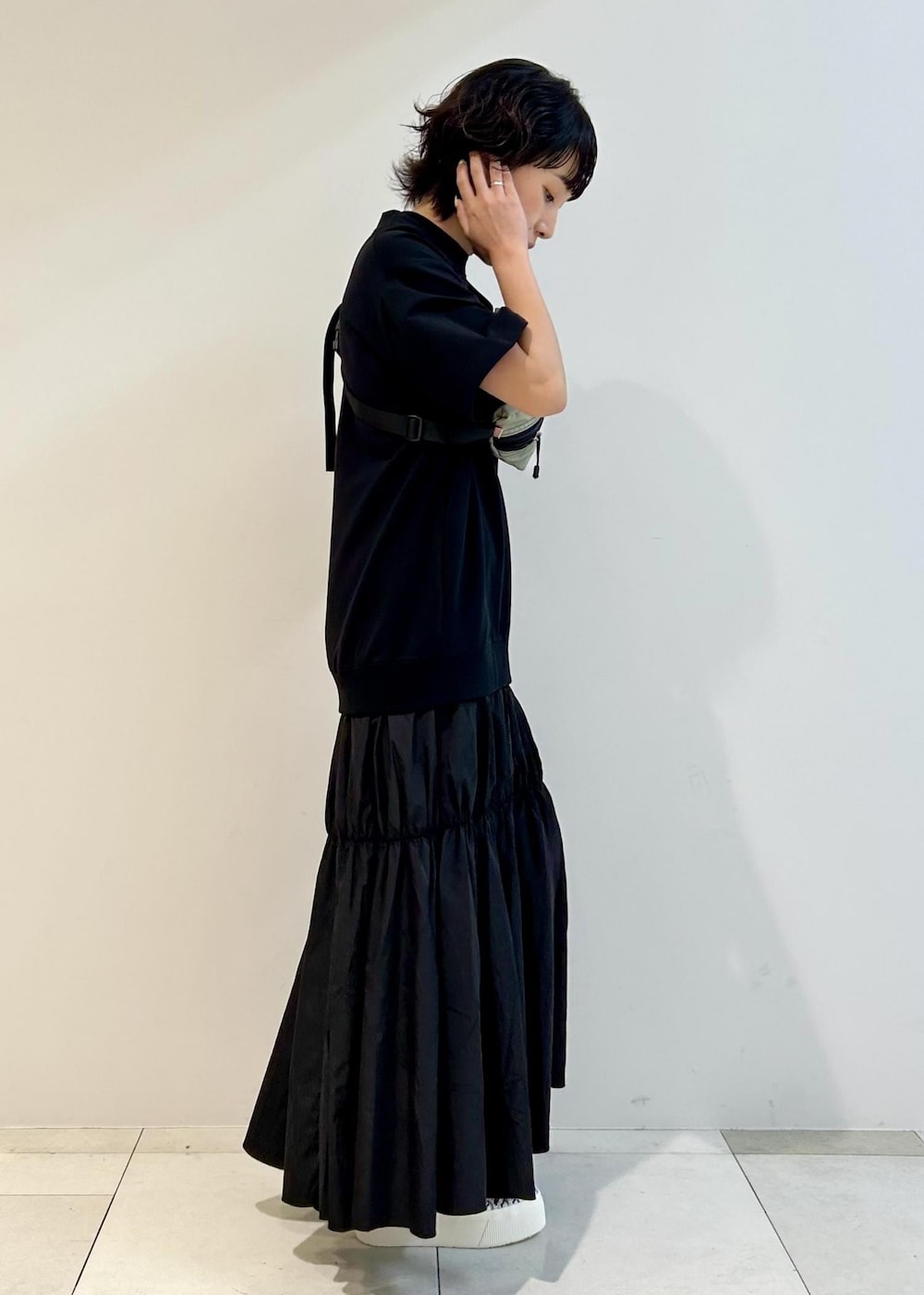 ブラック系のスニーカー、グレー系のボディバッグ/ウエストポーチ、ブラック系のワンピースを着用したレディースの夏コーディネートの4枚目の写真