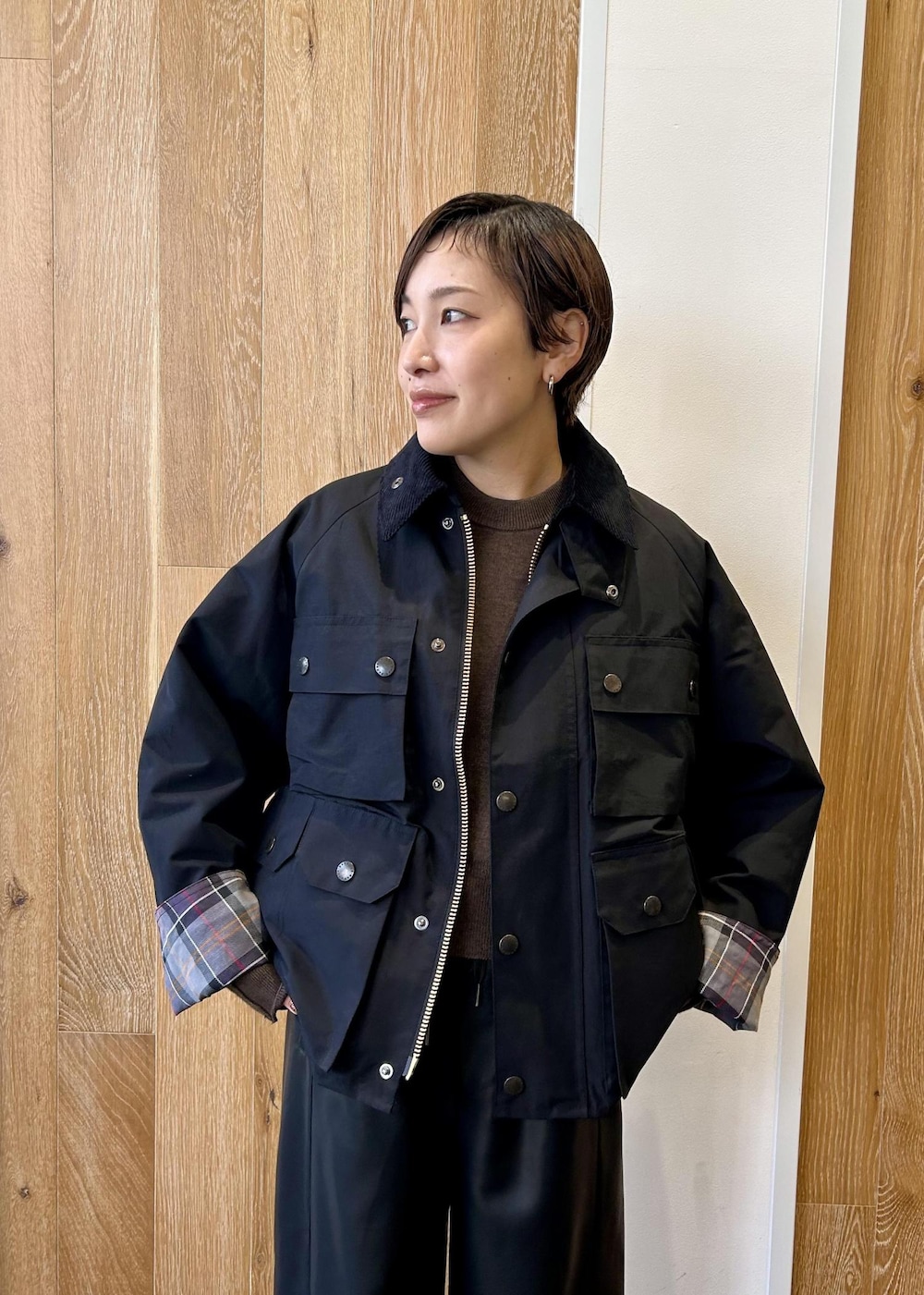 グリーン系のショルダーバッグ、ブラック系のブルゾン、ブラウン系のニット/セーターを着用したレディースの秋コーディネートの6枚目の写真