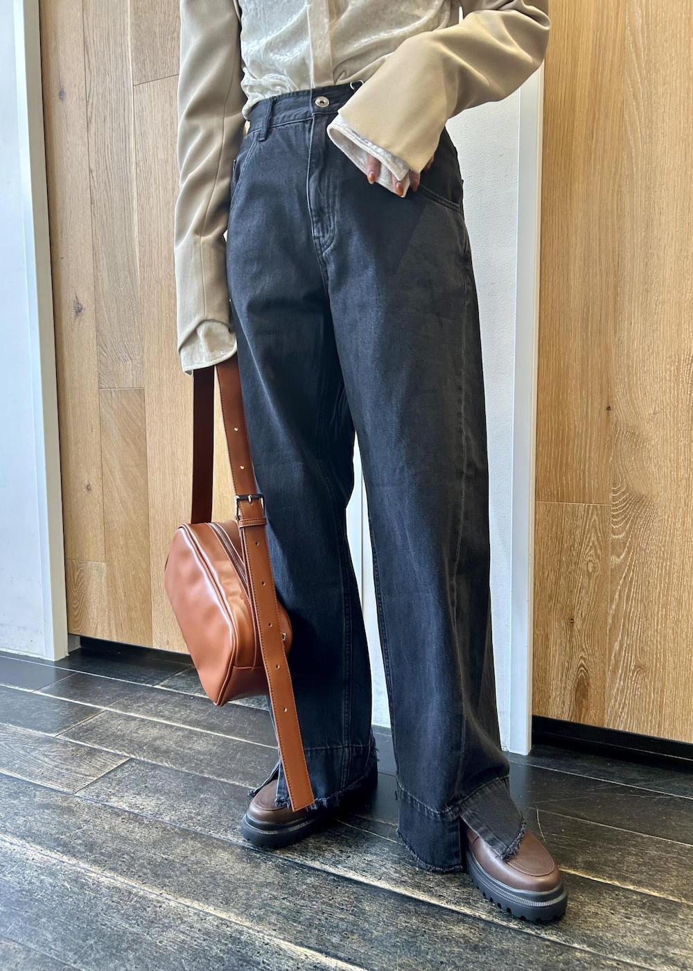 ブラック系のデニムパンツ、ブラウン系のショルダーバッグ、ブラウン系のローファーを着用したレディースの秋コーディネートの7枚目の写真