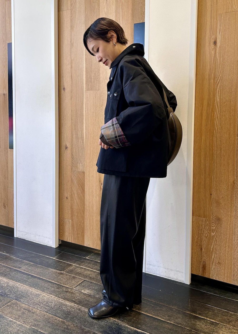 グリーン系のショルダーバッグ、ブラック系のブルゾン、ブラウン系のニット/セーターを着用したレディースの秋コーディネートの3枚目の写真