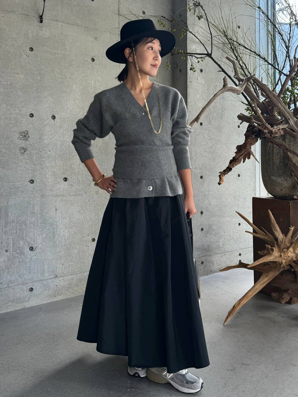 グレー系のカーディガン/ボレロ、ブラック系のスカート、グレー系のチューブトップを着用したレディースの秋コーディネートの7枚目の写真