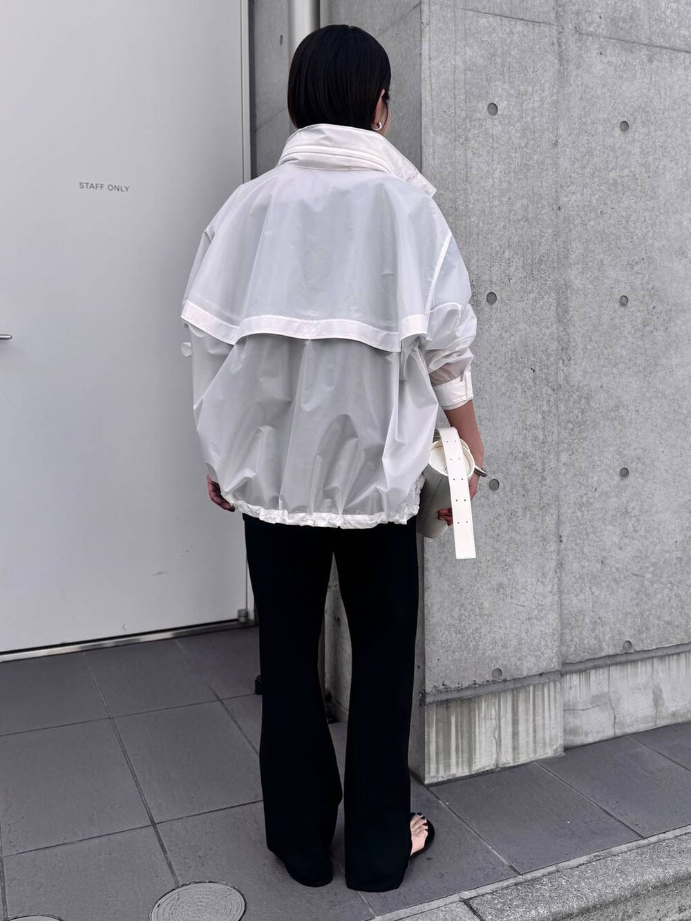 ホワイト系のブルゾン、ブラック系のその他パンツ、ブラック系のシャツ/ブラウスを着用したレディースの夏コーディネートの3枚目の写真