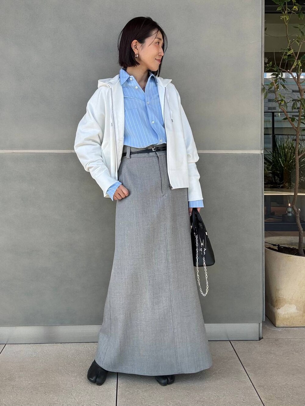 ホワイト系のパーカー、グレー系のスカートを着用したレディースの冬コーディネートの7枚目の写真