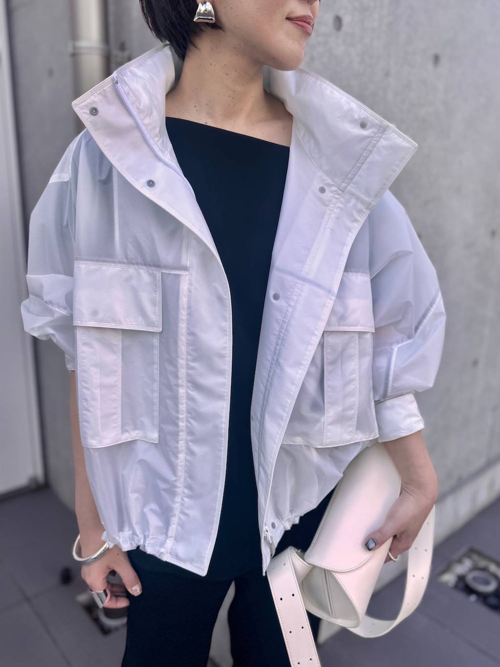 ホワイト系のブルゾン、ブラック系のその他パンツ、ブラック系のシャツ/ブラウスを着用したレディースの夏コーディネートの4枚目の写真