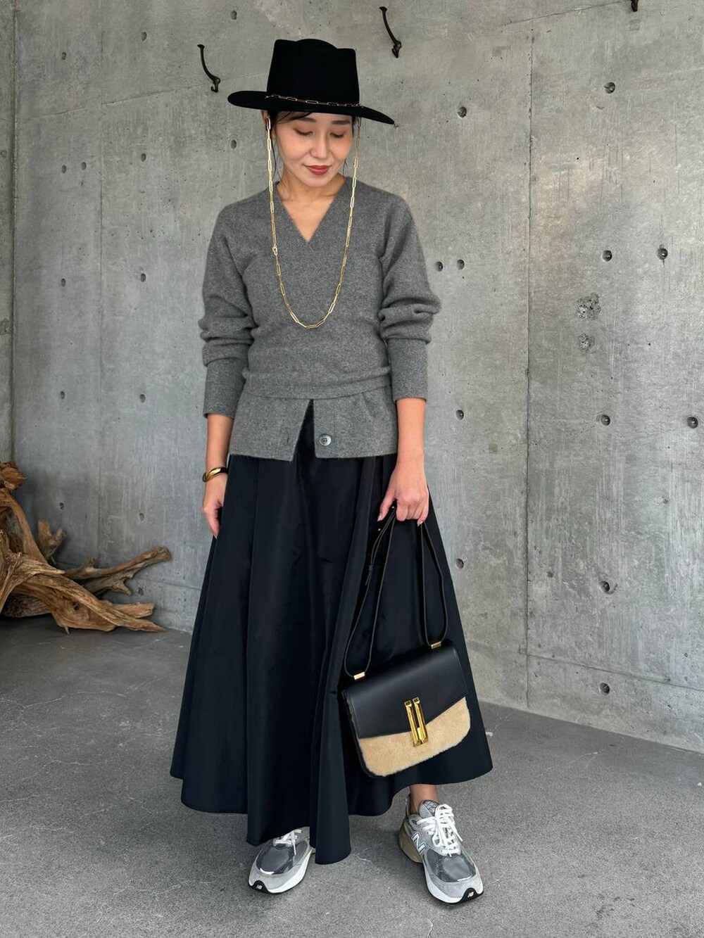 グレー系のカーディガン/ボレロ、ブラック系のスカート、グレー系のチューブトップを着用したレディースの秋コーディネートの2枚目の写真