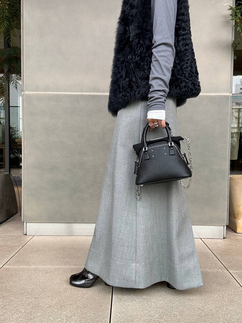 グレー系のスカート、グレー系のTシャツ/カットソーを着用したレディースの秋コーディネートの7枚目の写真