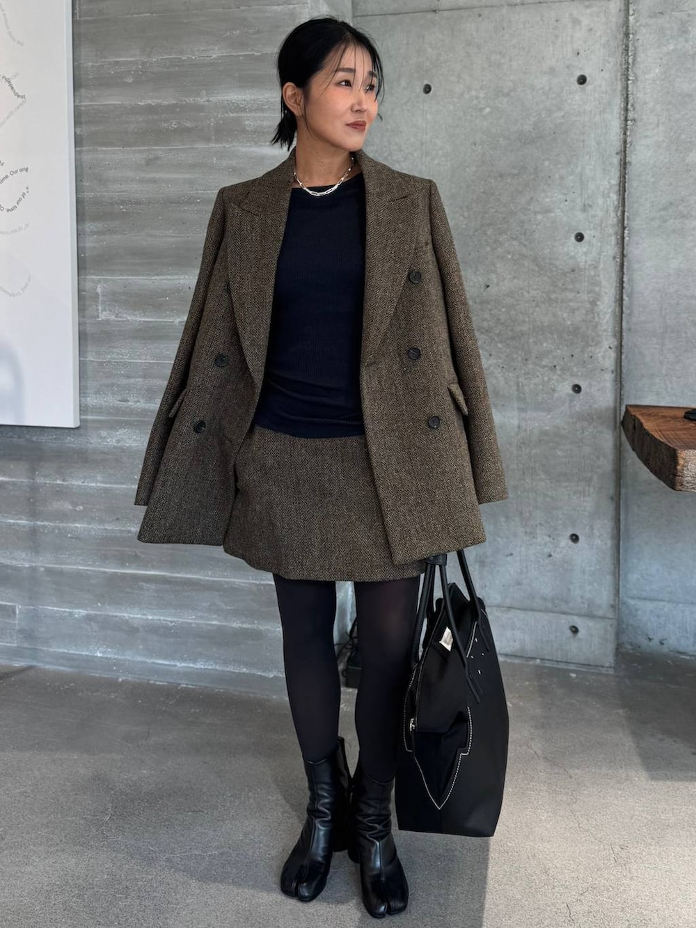 ブルー系のニット/セーター、ブルー系のニット/セーター、ブラウン系のテーラードジャケットを着用したレディースの秋コーディネートの2枚目の写真