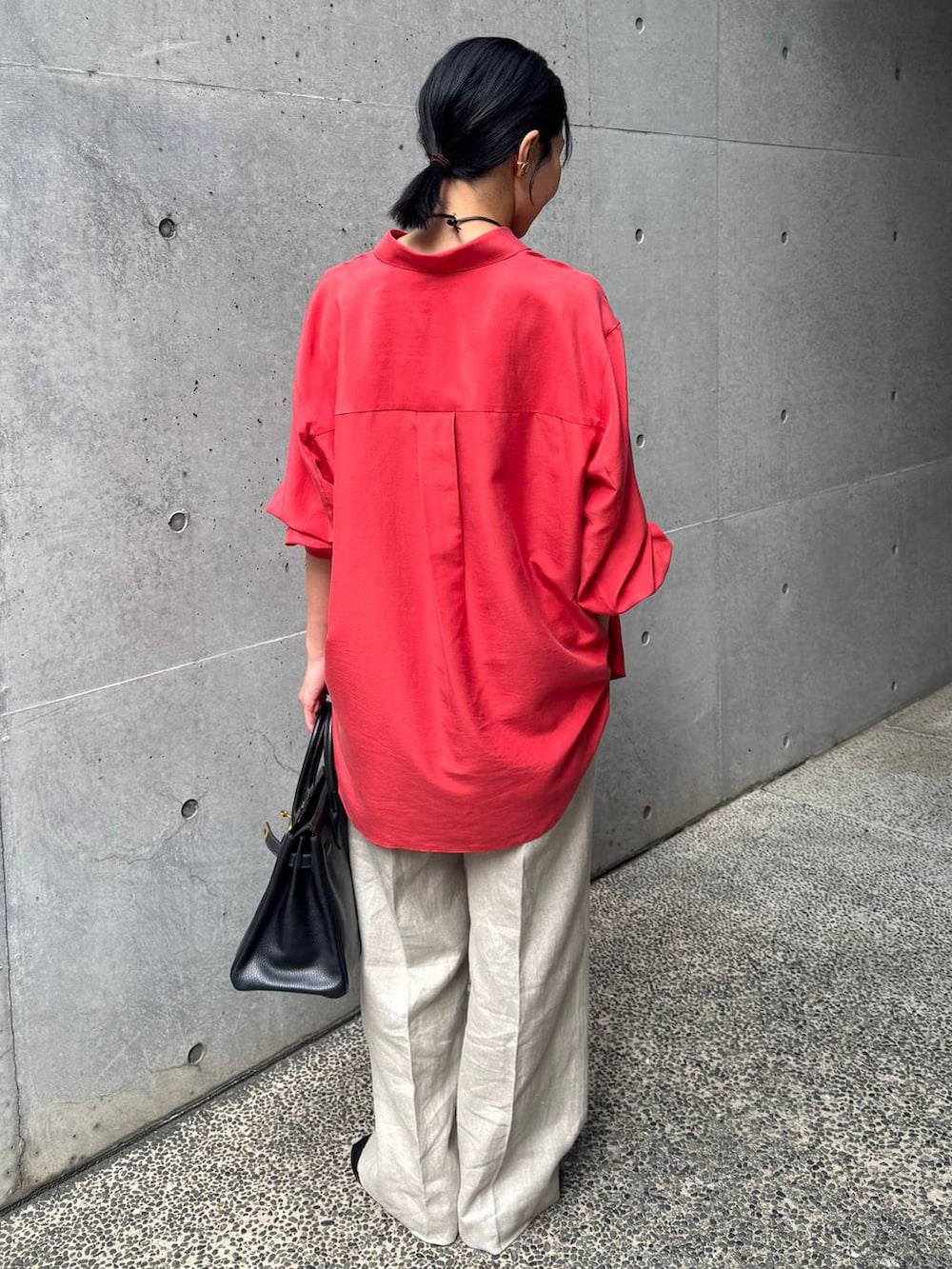 レッド系のシャツ/ブラウス、ホワイト系のスラックスを着用したレディースの春コーディネートの3枚目の写真