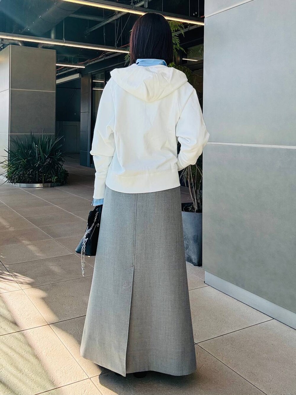 ホワイト系のパーカー、グレー系のスカートを着用したレディースの冬コーディネートの3枚目の写真