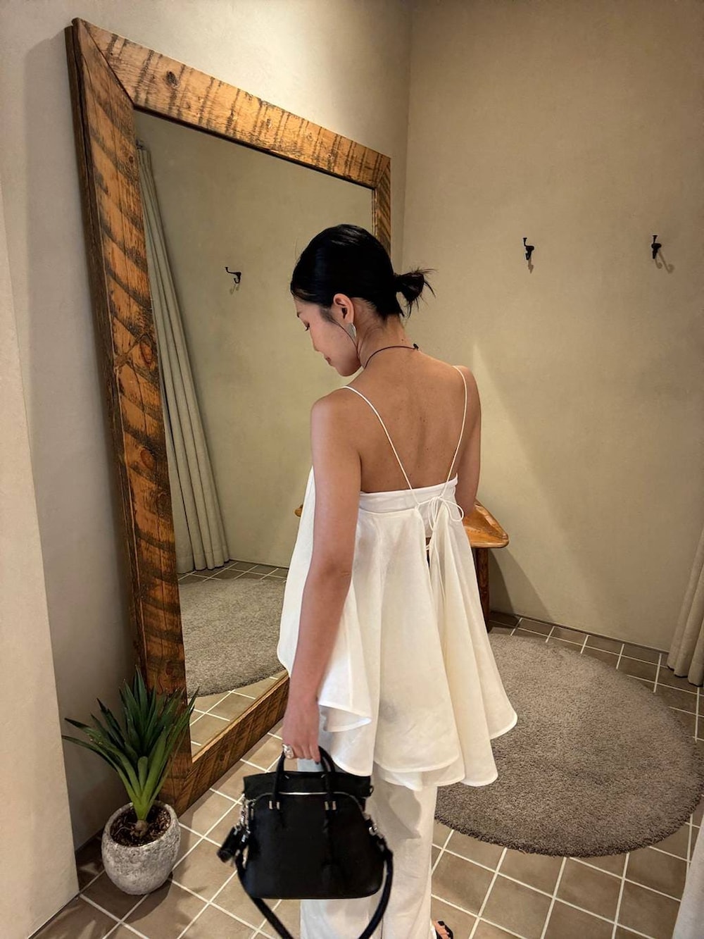 ホワイト系のデニムパンツ、ブラック系のテーラードジャケット、ホワイト系のキャミソールを着用したレディースの春コーディネートの9枚目の写真