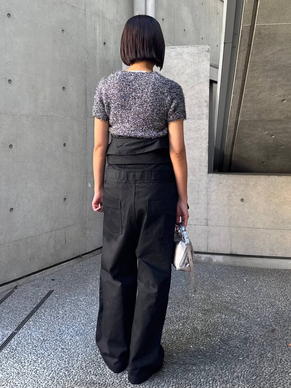 ブラック系のブルゾン、シルバー系のニット/セーター、ブラック系のつなぎ/オールインワンを着用したレディースの冬コーディネートの4枚目の写真