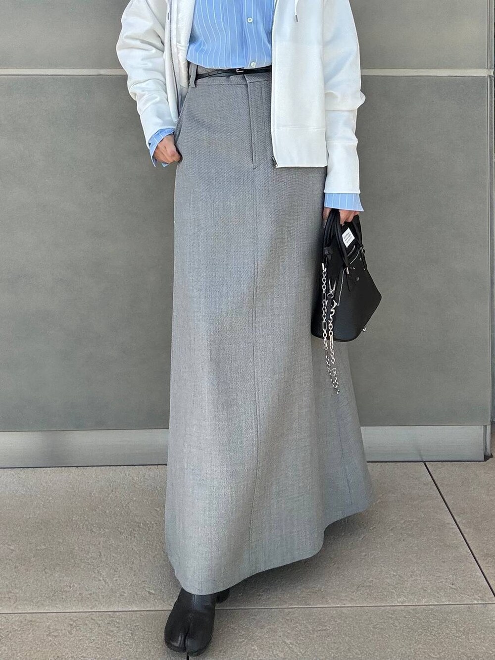 ホワイト系のパーカー、グレー系のスカートを着用したレディースの冬コーディネートの5枚目の写真