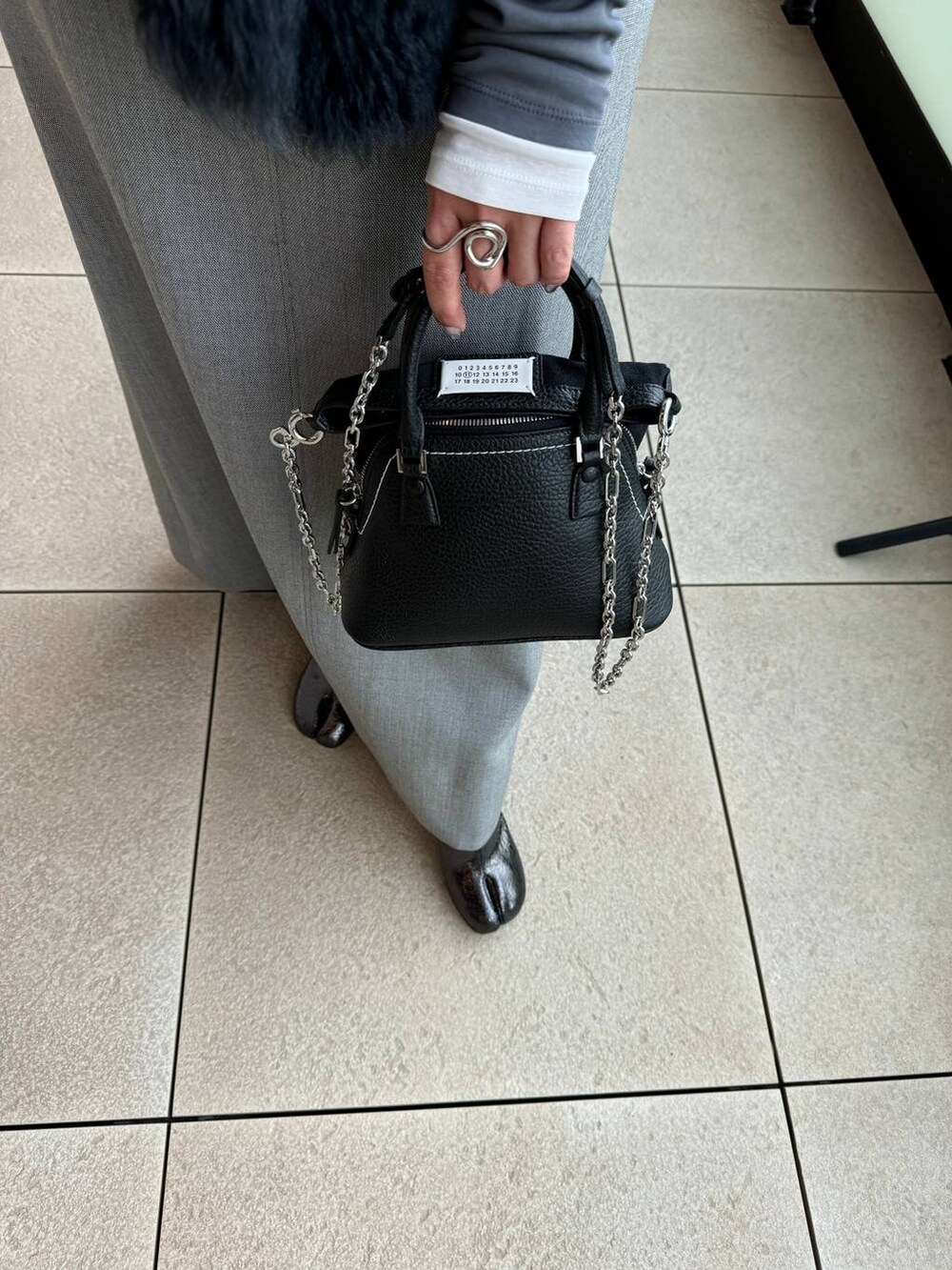 グレー系のスカート、グレー系のTシャツ/カットソーを着用したレディースの秋コーディネートの8枚目の写真