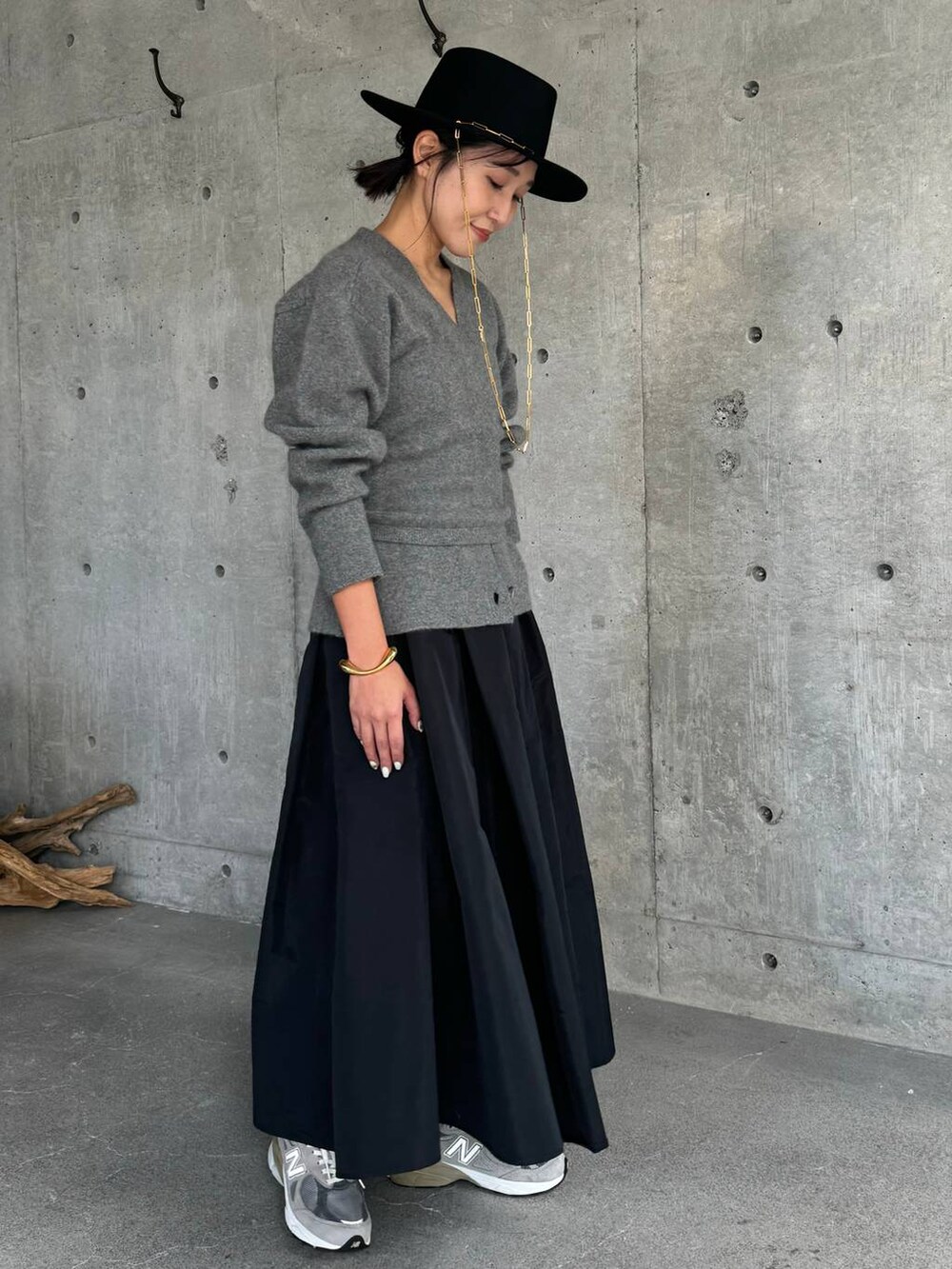 グレー系のカーディガン/ボレロ、ブラック系のスカート、グレー系のチューブトップを着用したレディースの秋コーディネートの3枚目の写真