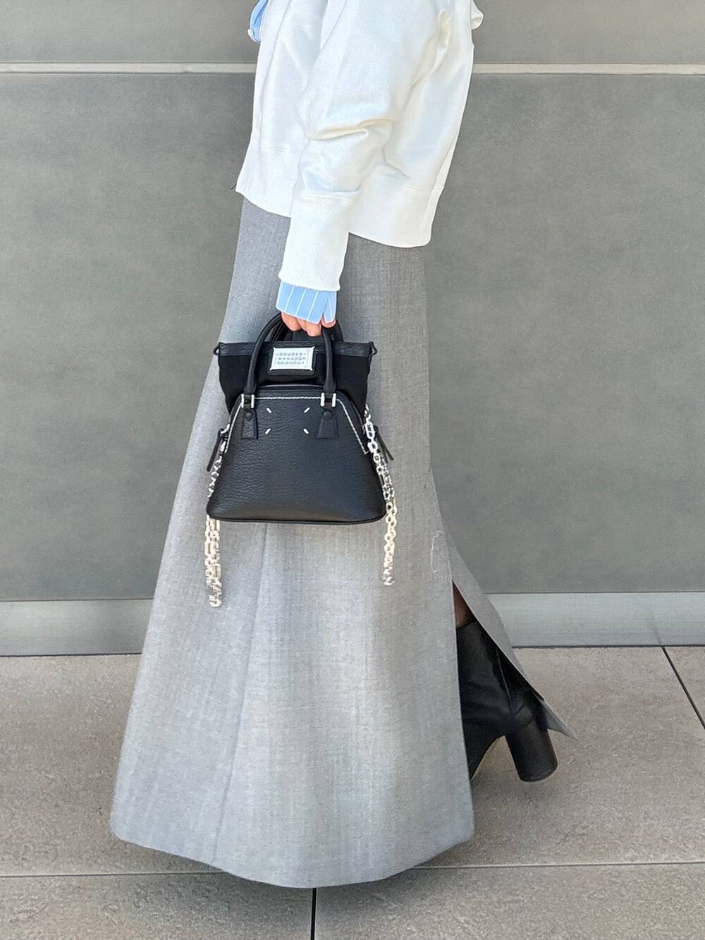 ホワイト系のパーカー、グレー系のスカートを着用したレディースの冬コーディネートの6枚目の写真