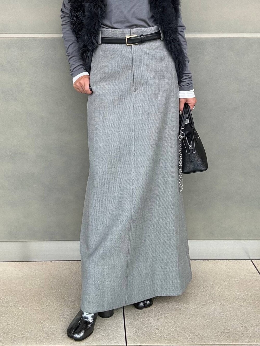 グレー系のスカート、グレー系のTシャツ/カットソーを着用したレディースの秋コーディネートの6枚目の写真