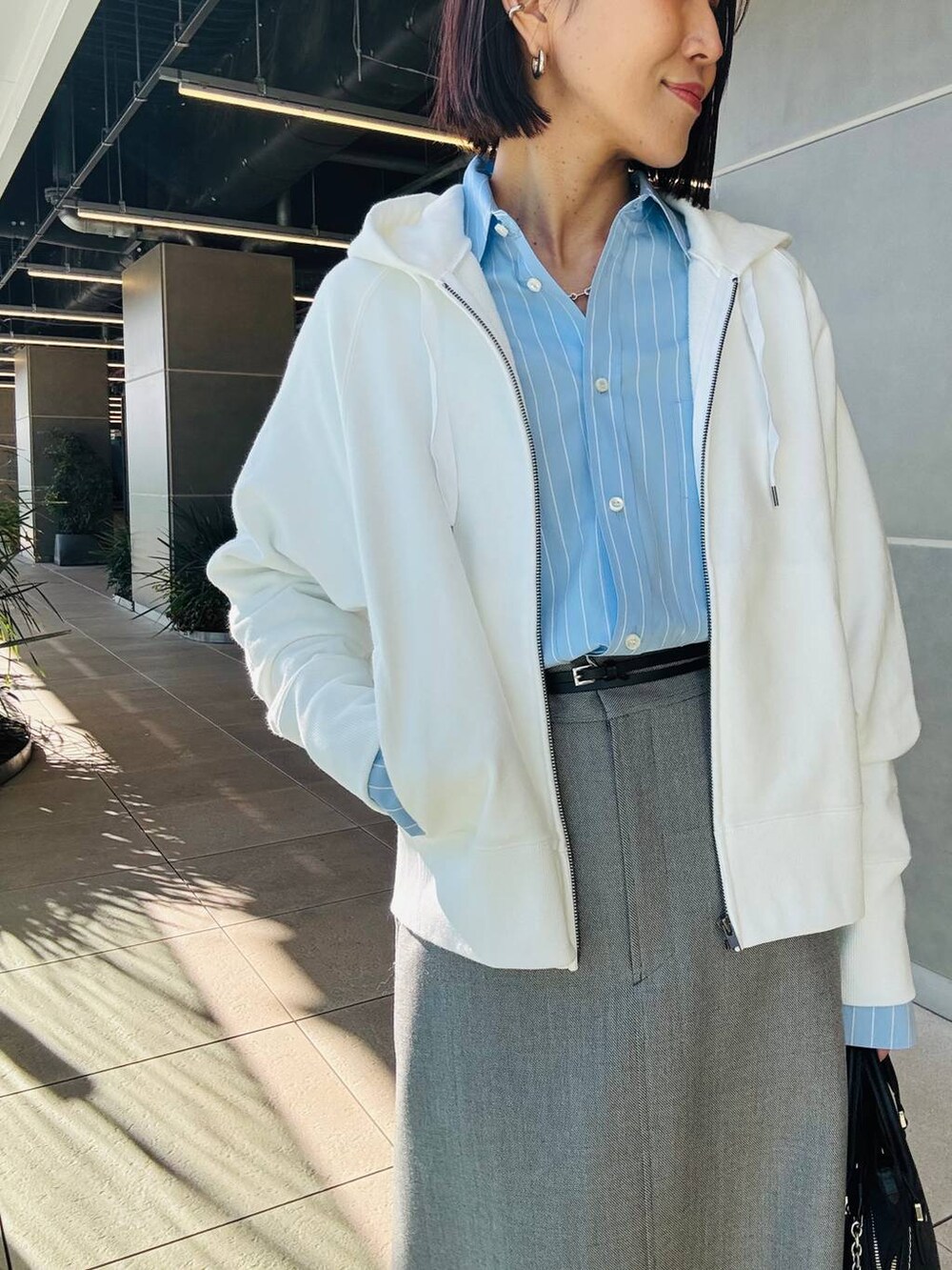 ホワイト系のパーカー、グレー系のスカートを着用したレディースの冬コーディネートの4枚目の写真