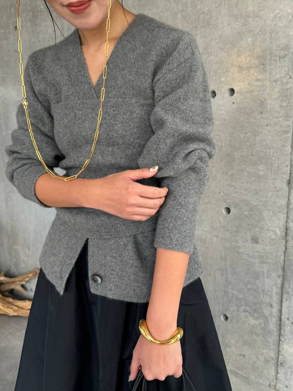 グレー系のカーディガン/ボレロ、ブラック系のスカート、グレー系のチューブトップを着用したレディースの秋コーディネートの4枚目の写真