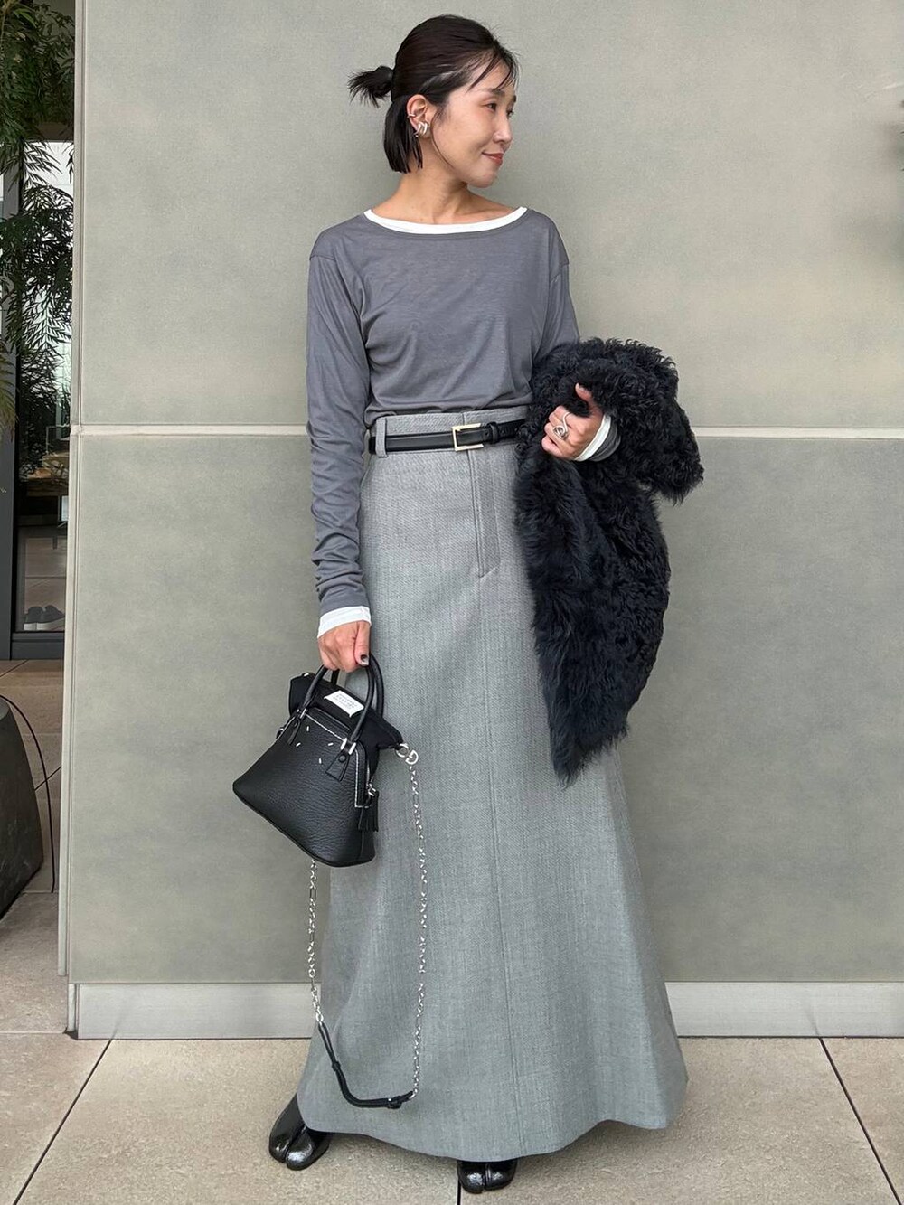 グレー系のスカート、グレー系のTシャツ/カットソーを着用したレディースの秋コーディネートの3枚目の写真