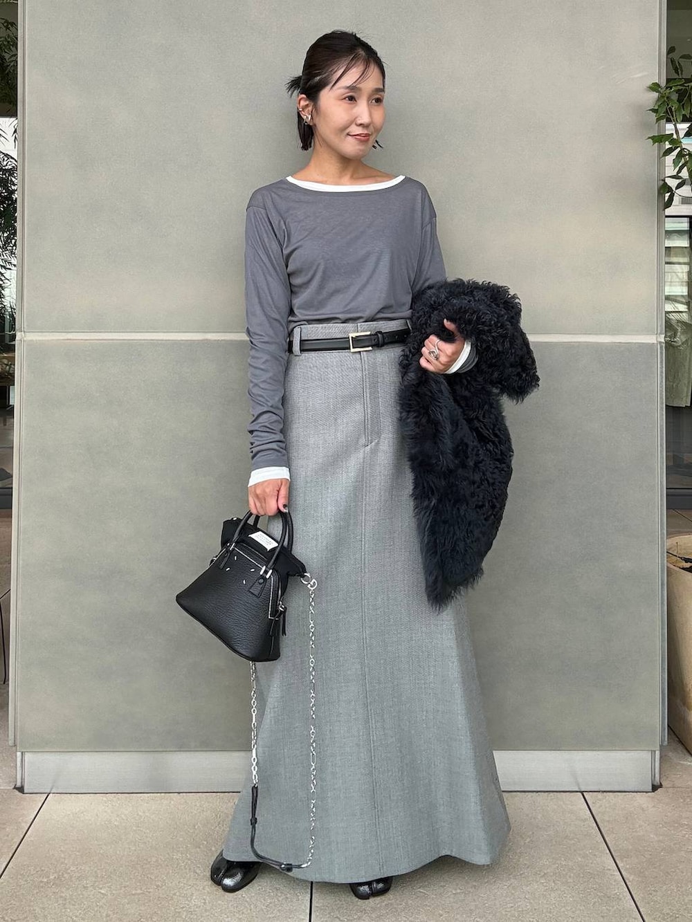 グレー系のスカート、グレー系のTシャツ/カットソーを着用したレディースの秋コーディネートの2枚目の写真