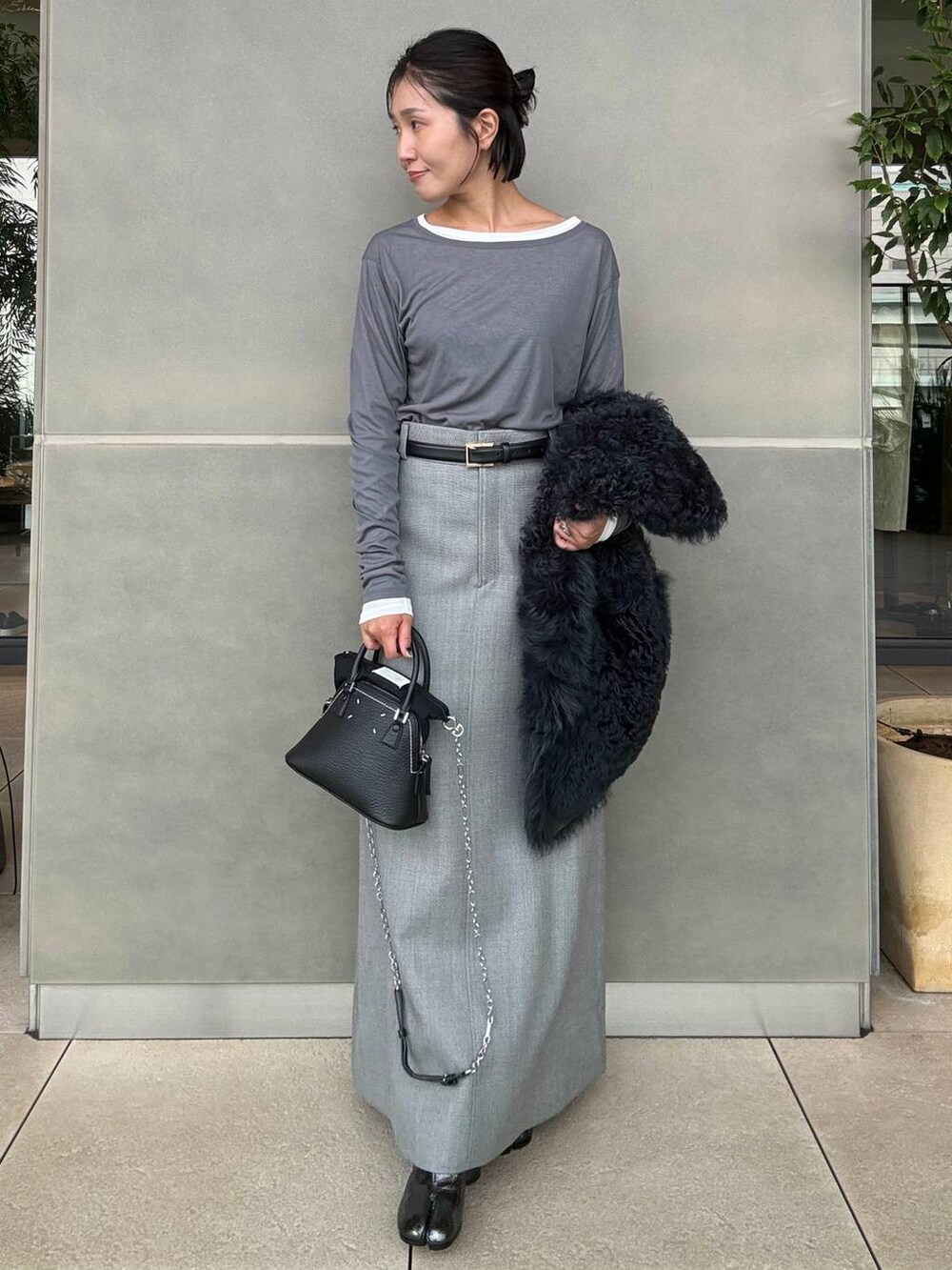 グレー系のスカート、グレー系のTシャツ/カットソーを着用したレディースの秋コーディネートの4枚目の写真