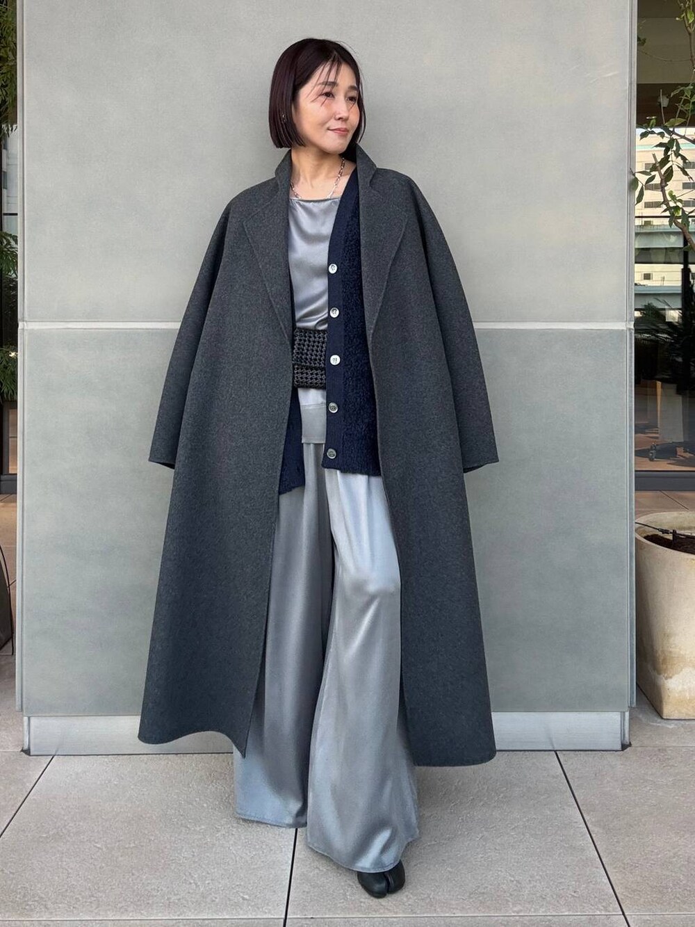 グレー系のその他パンツ、ブルー系のカーディガン/ボレロ、グレー系のノーカラーコートを着用したレディースの冬コーディネートの2枚目の写真