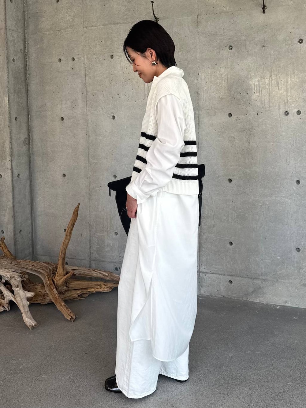 ホワイト系のデニムパンツ、ホワイト系のワンピース、その他のベストを着用したレディースの春コーディネートの3枚目の写真