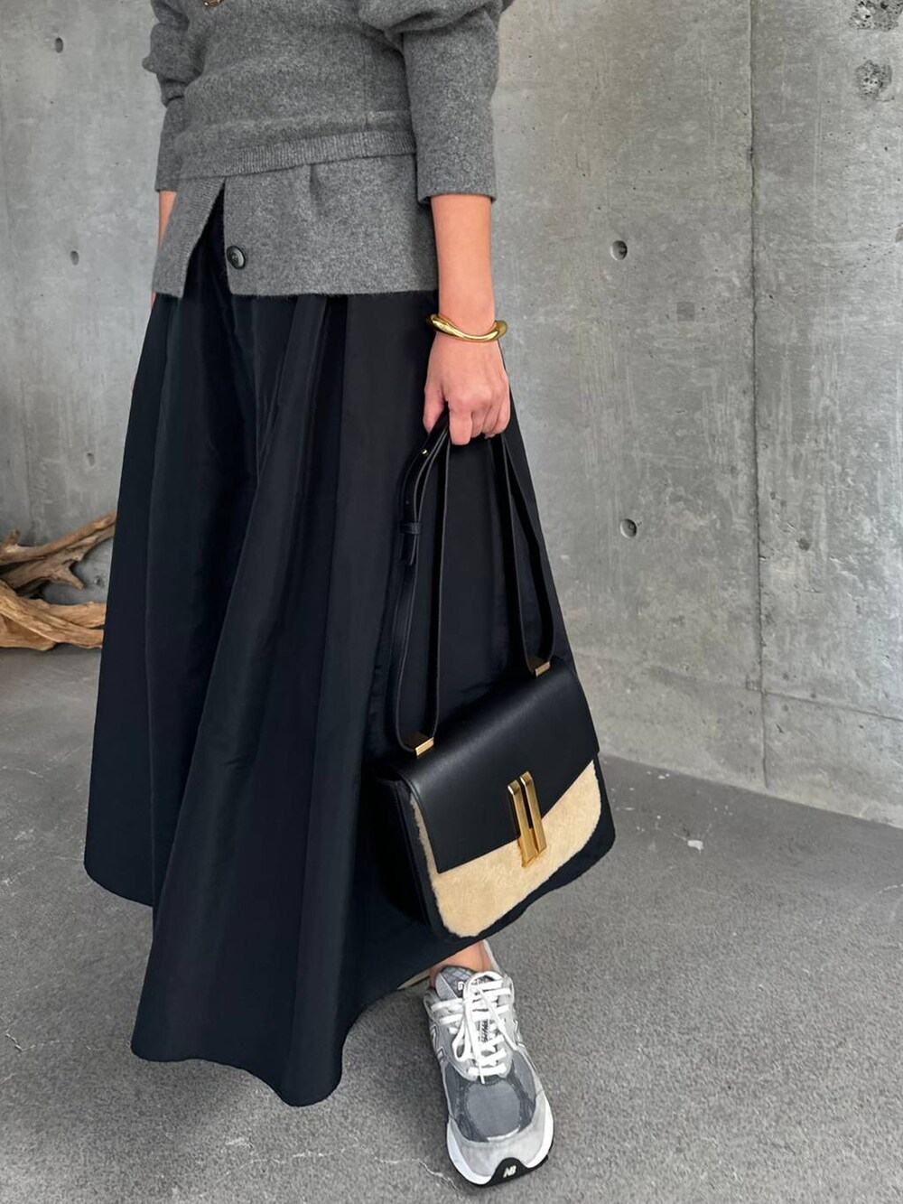 グレー系のカーディガン/ボレロ、ブラック系のスカート、グレー系のチューブトップを着用したレディースの秋コーディネートの6枚目の写真