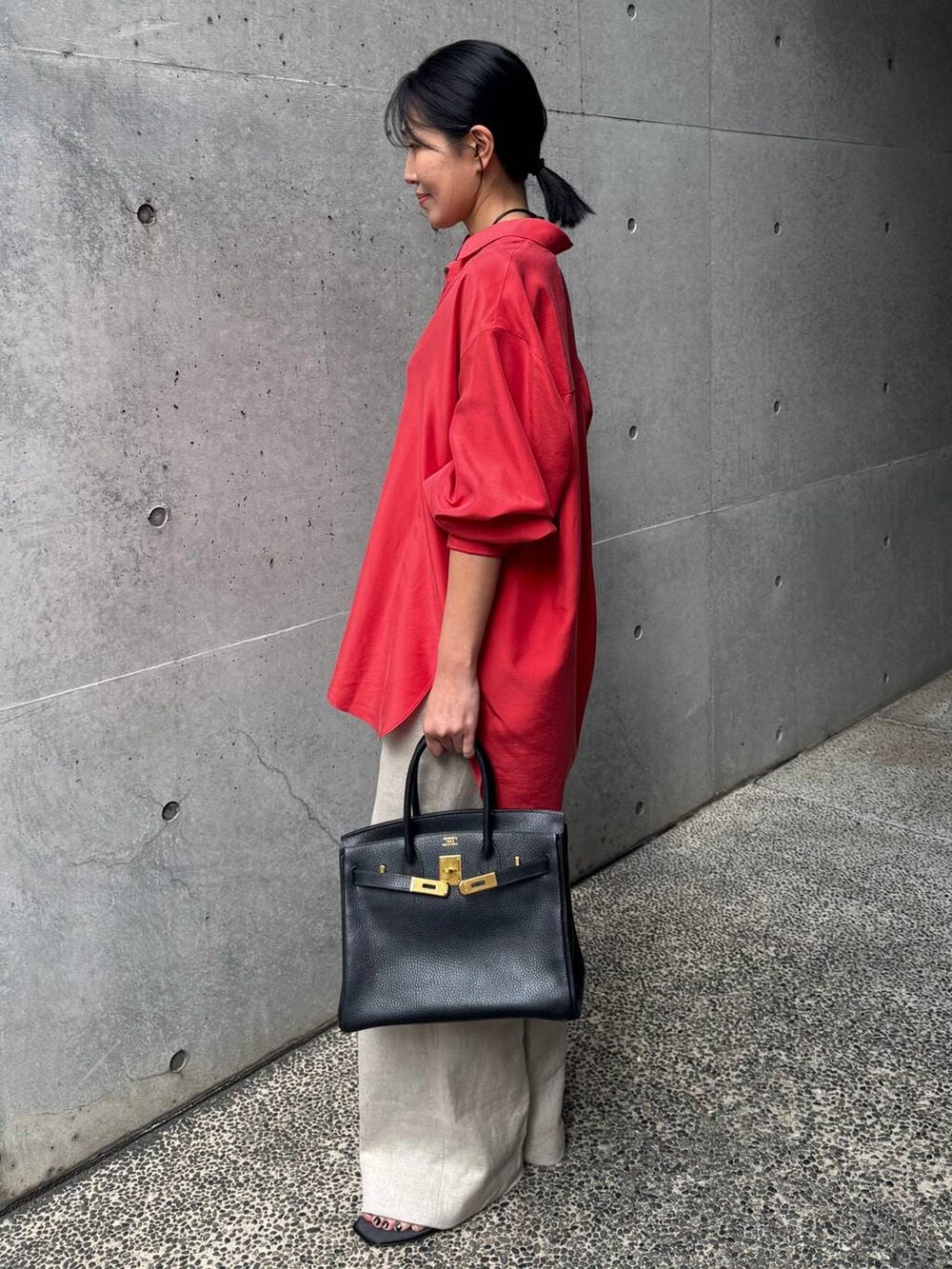 レッド系のシャツ/ブラウス、ホワイト系のスラックスを着用したレディースの春コーディネートの2枚目の写真