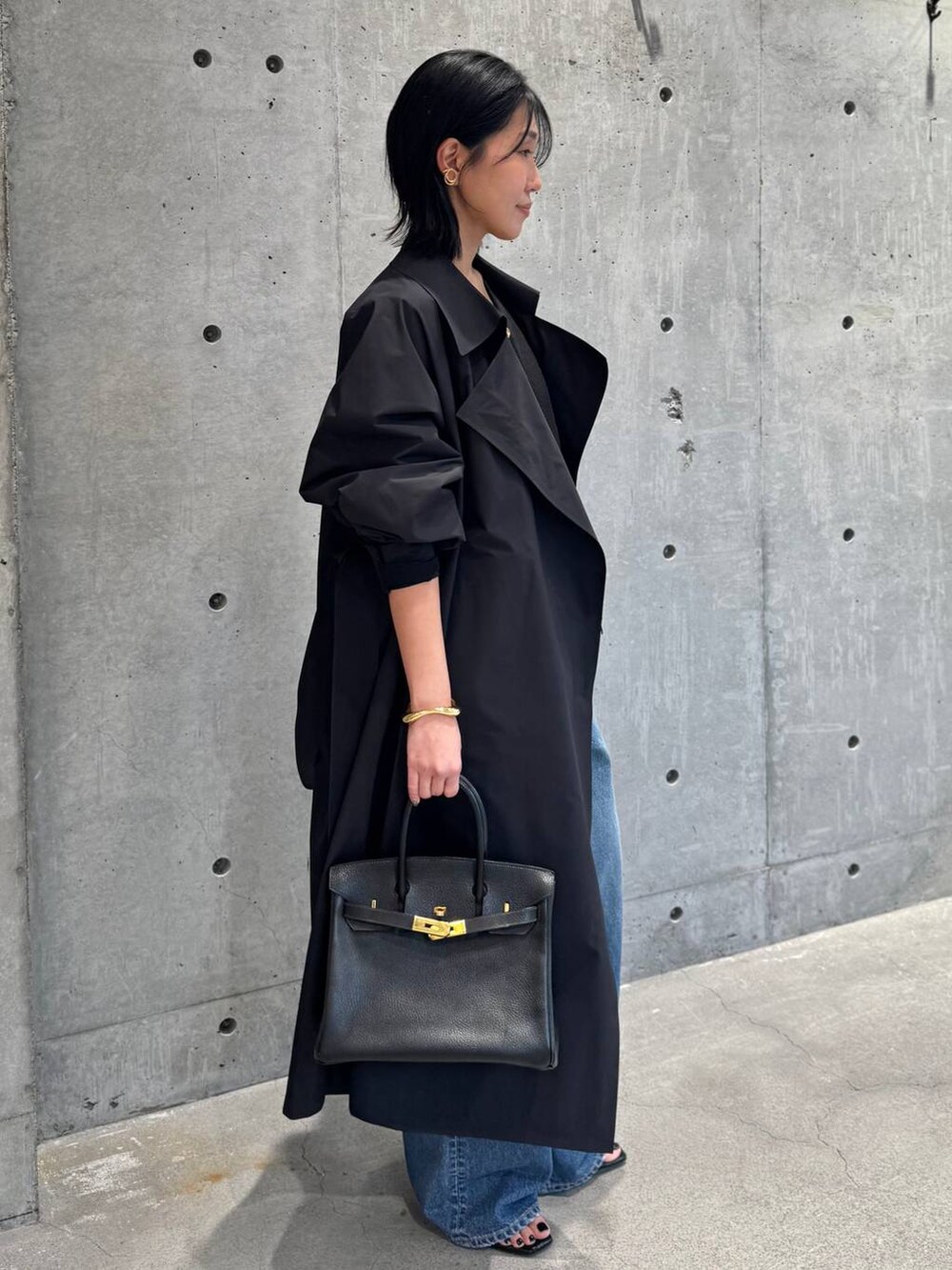 ブルー系のデニムパンツ、ブラック系のカーディガン/ボレロを着用したレディースの冬コーディネートの2枚目の写真