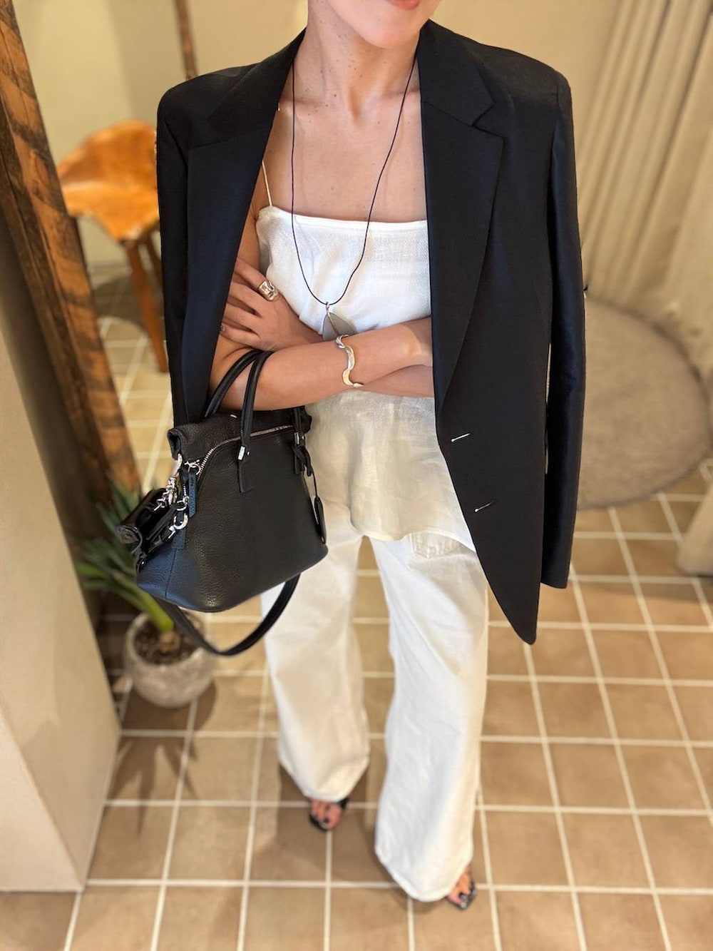 ホワイト系のデニムパンツ、ブラック系のテーラードジャケット、ホワイト系のキャミソールを着用したレディースの春コーディネートの8枚目の写真