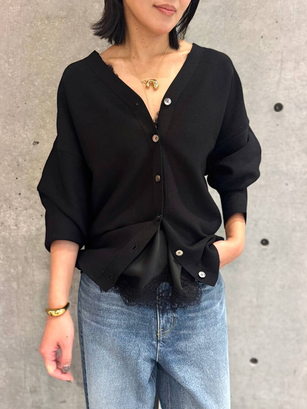 ブルー系のデニムパンツ、ブラック系のカーディガン/ボレロを着用したレディースの冬コーディネートの6枚目の写真