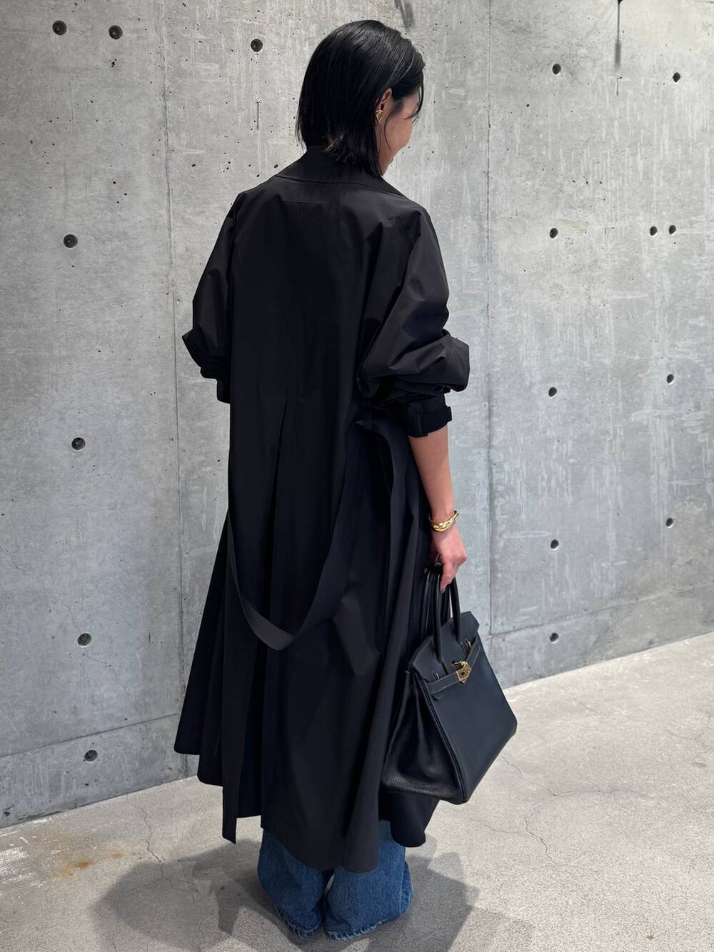 ブルー系のデニムパンツ、ブラック系のカーディガン/ボレロを着用したレディースの冬コーディネートの3枚目の写真