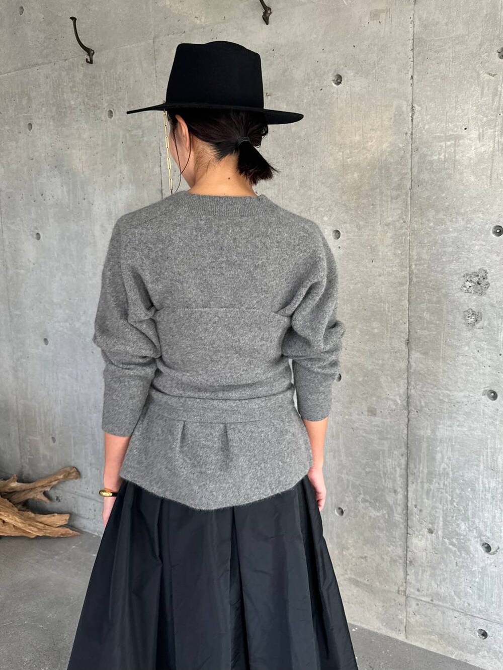 グレー系のカーディガン/ボレロ、ブラック系のスカート、グレー系のチューブトップを着用したレディースの秋コーディネートの5枚目の写真