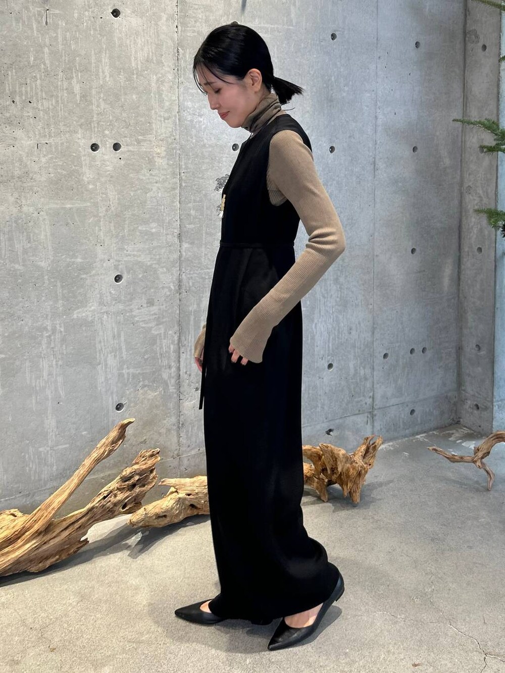 ベージュ系のニット/セーター、ブラック系のつなぎ/オールインワンを着用したレディースの冬コーディネートの4枚目の写真