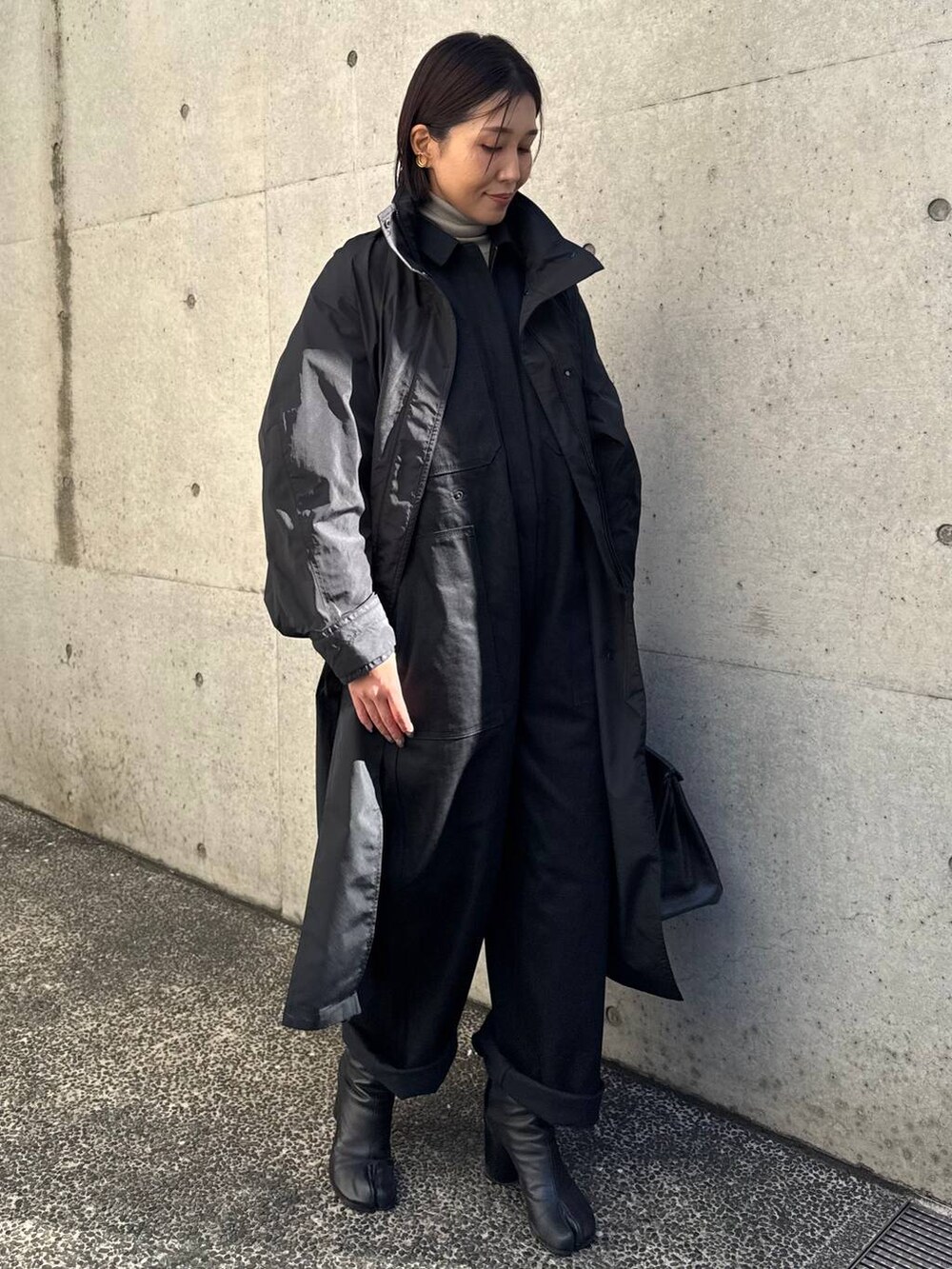 ブラック系のナイロンジャケット、ベージュ系のニット/セーター、ブラック系のつなぎ/オールインワンを着用したレディースの冬コーディネートの8枚目の写真
