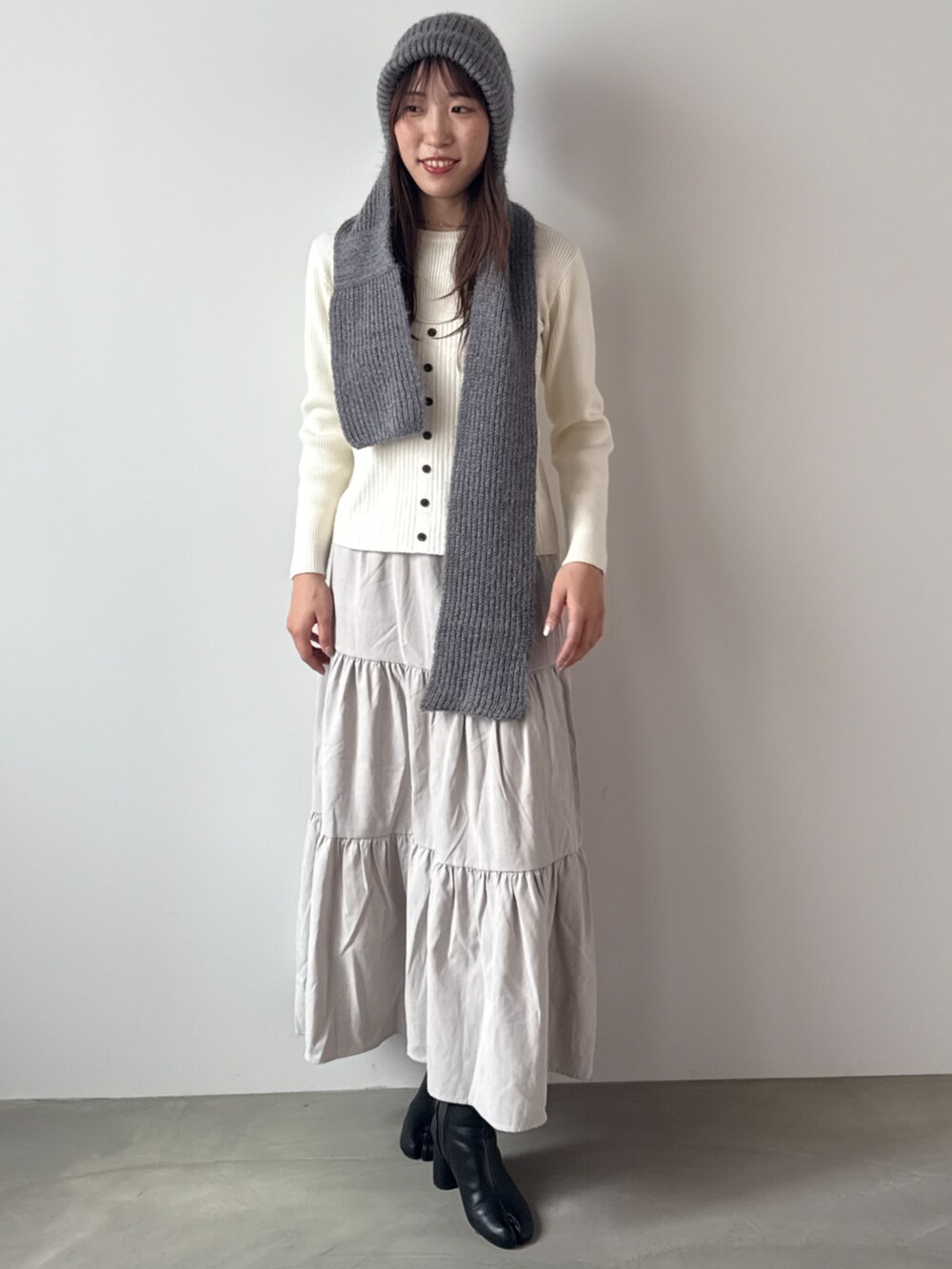 ホワイト系のニット/セーター、グレー系のニットキャップ/ビーニーを着用したレディースの秋コーディネートの2枚目の写真