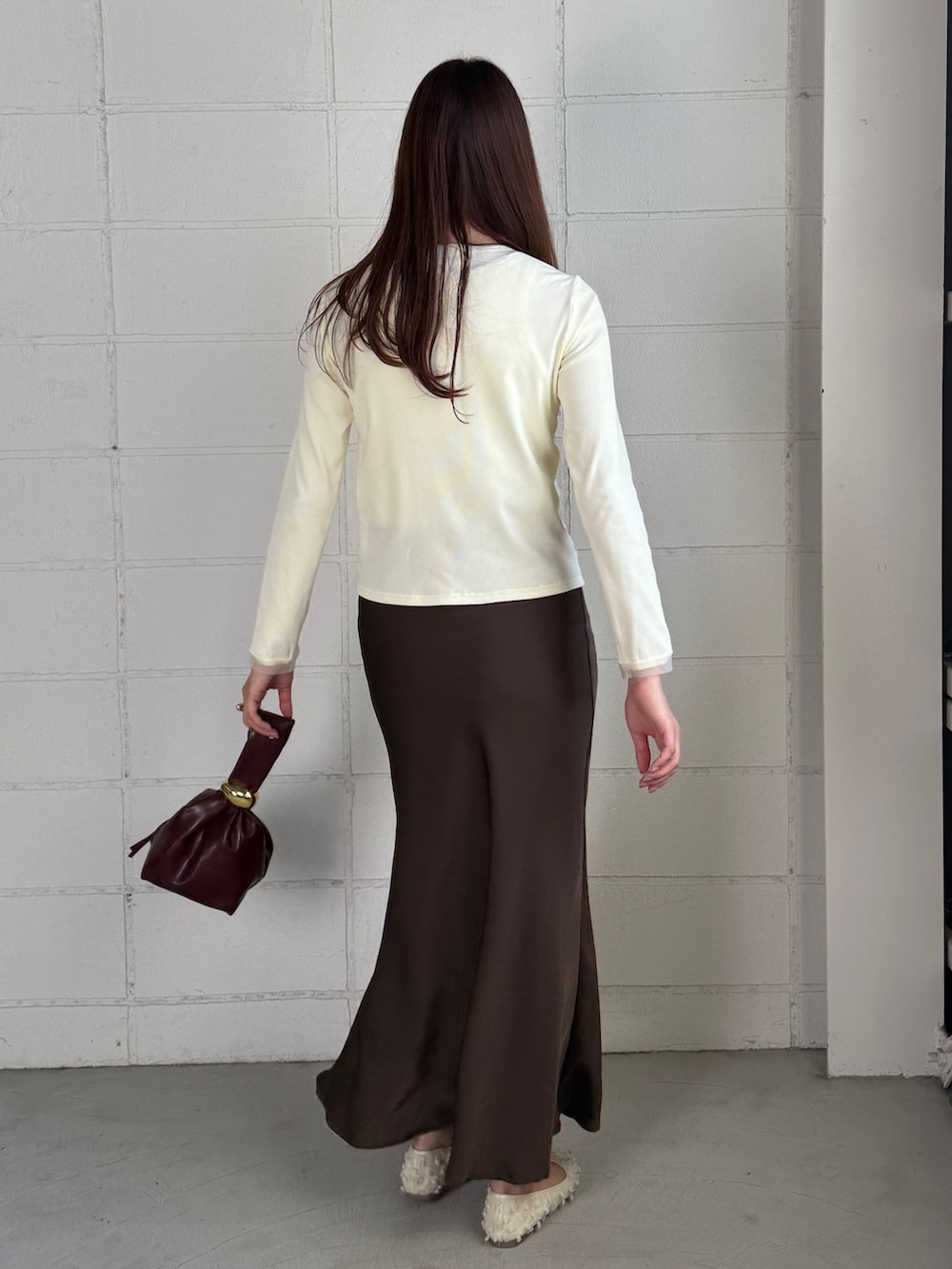 ホワイト系のカーディガン/ボレロ、ブラウン系のスカートを着用したレディースの秋コーディネートの2枚目の写真