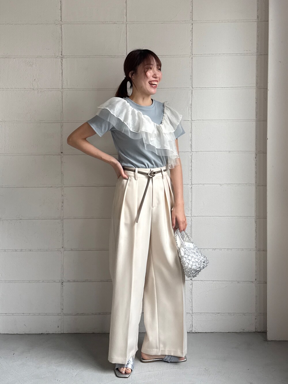 ブルー系のTシャツ/カットソー、ホワイト系のスラックスを着用したレディースの夏コーディネートの2枚目の写真