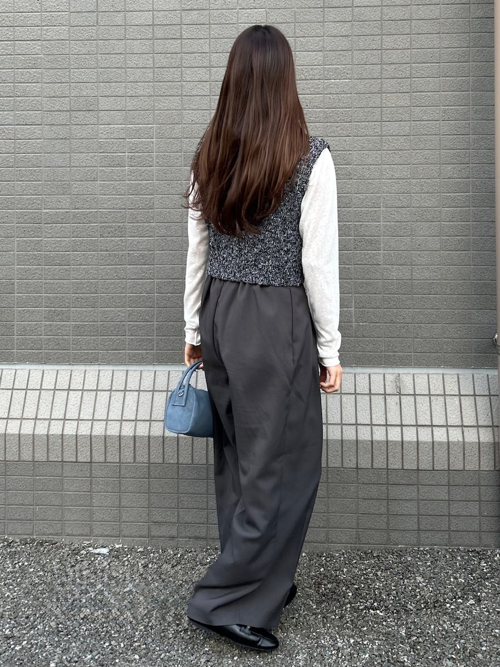 グレー系のその他パンツ、ブラック系のベスト、ブルー系のショルダーバッグを着用したレディースの春コーディネートの2枚目の写真