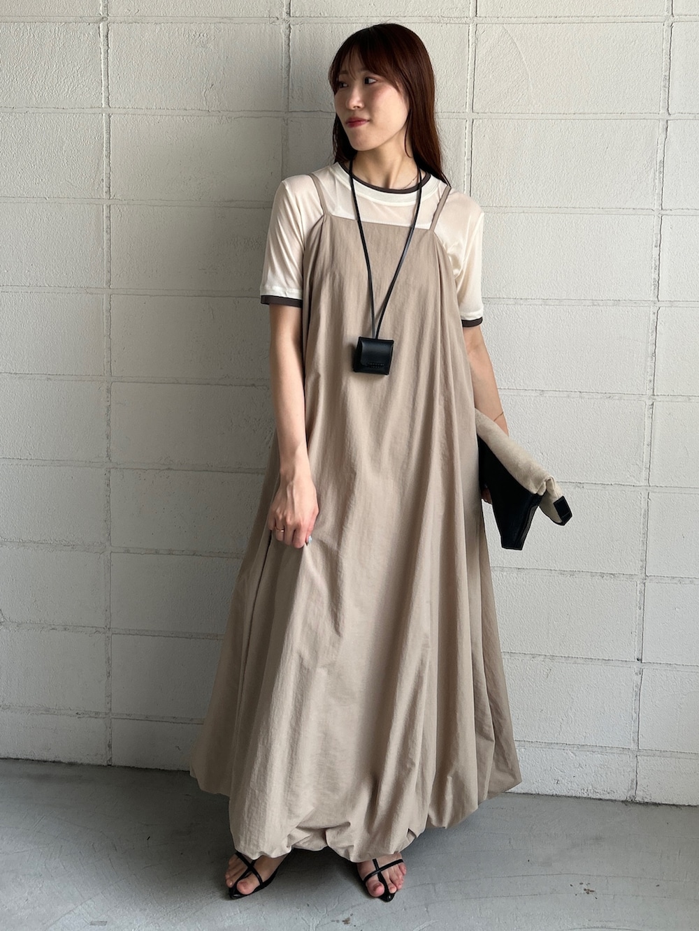 ベージュ系のワンピース、ホワイト系のTシャツ/カットソー、ベージュ系のショルダーバッグを着用したレディースの夏コーディネートの2枚目の写真