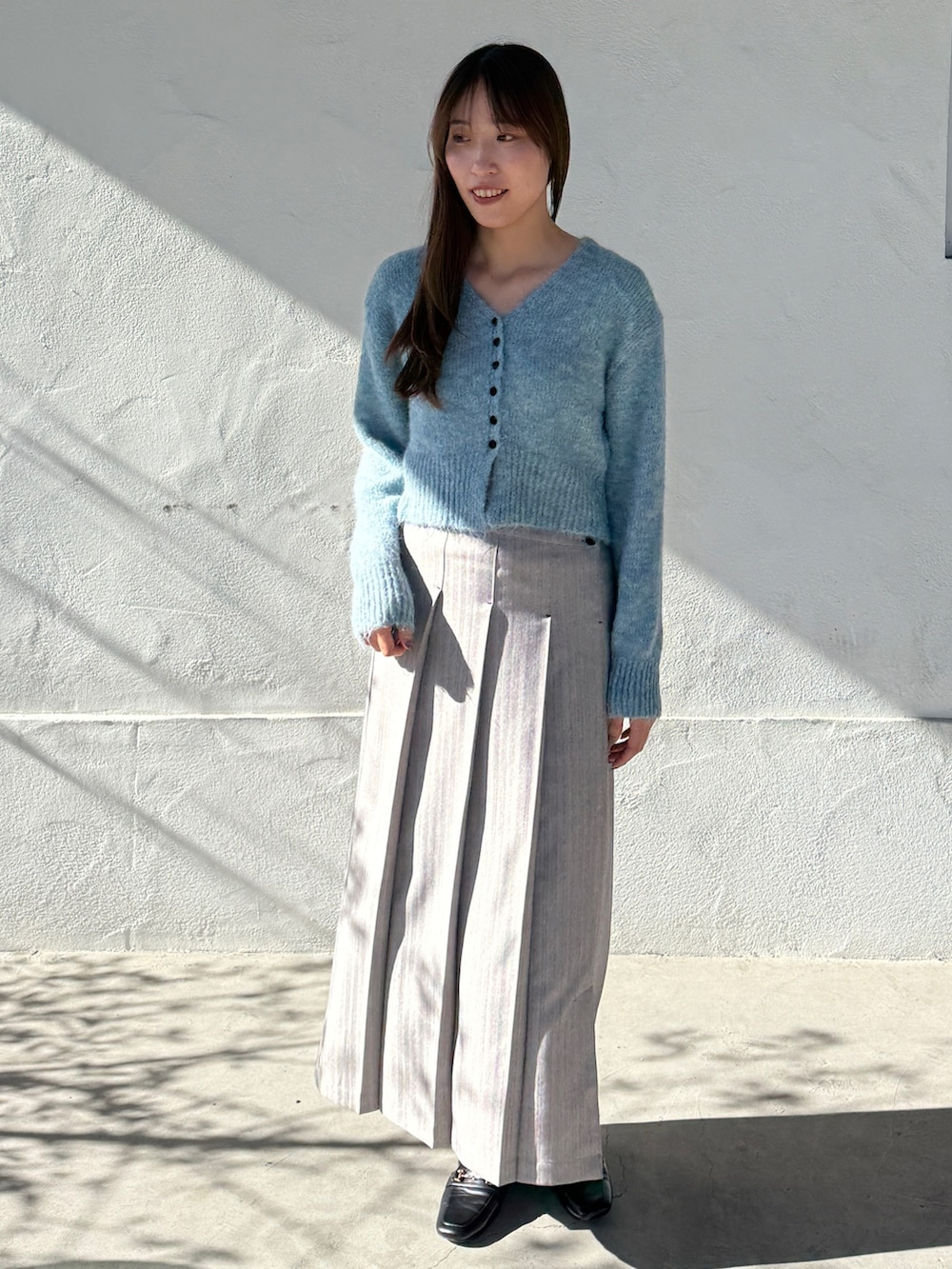 グレー系のスカート、ブルー系のカーディガン/ボレロを着用したレディースの秋コーディネートの2枚目の写真