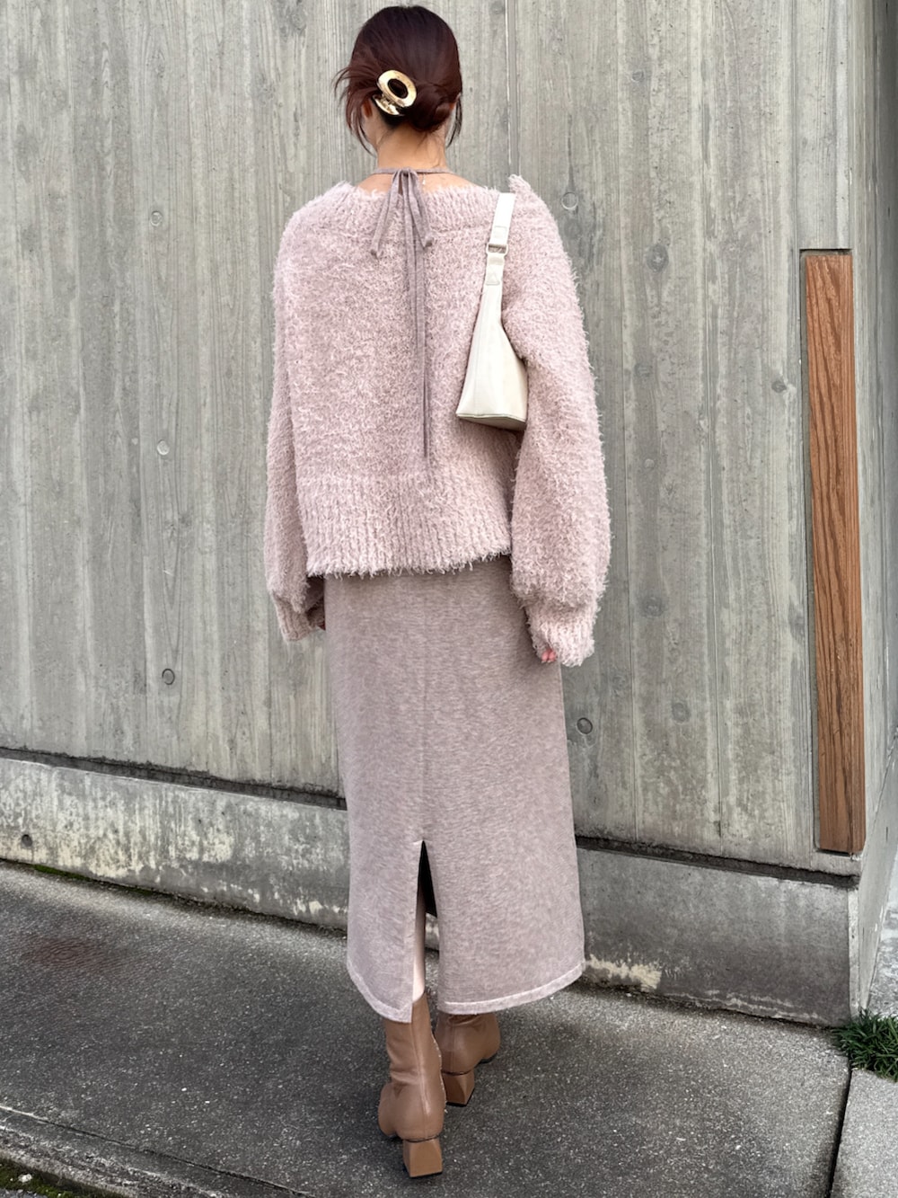 ベージュ系のワンピースを着用したレディースの冬コーディネートの2枚目の写真