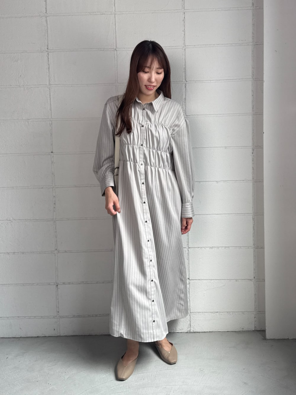 ホワイト系のシャツワンピースを着用したレディースの秋コーディネートの2枚目の写真
