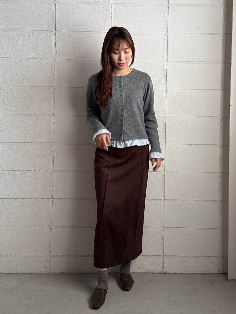 ブラウン系のスカート、グレー系のカーディガン/ボレロを着用したレディースの秋コーディネートの2枚目の写真